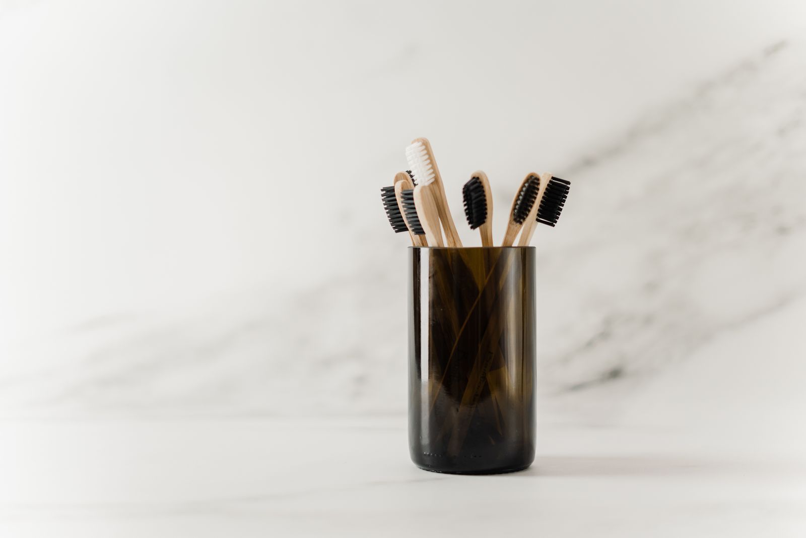 Bamboo toothbrushes in a glass holder