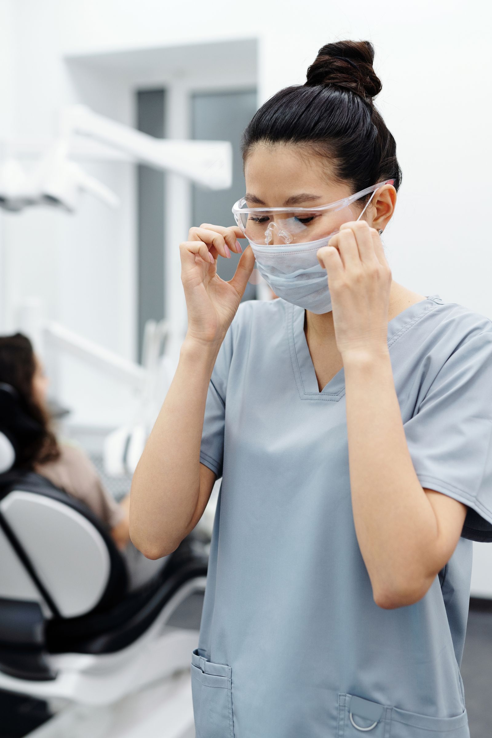 Dental team member putting on a mask and protective goggles
